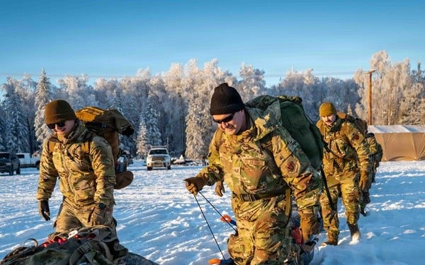 Group of soldiers hiking in the snow wearing beanies