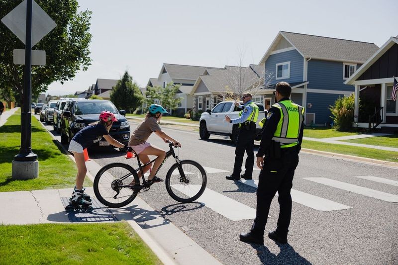 Police officers crossing guards with children on bicycles